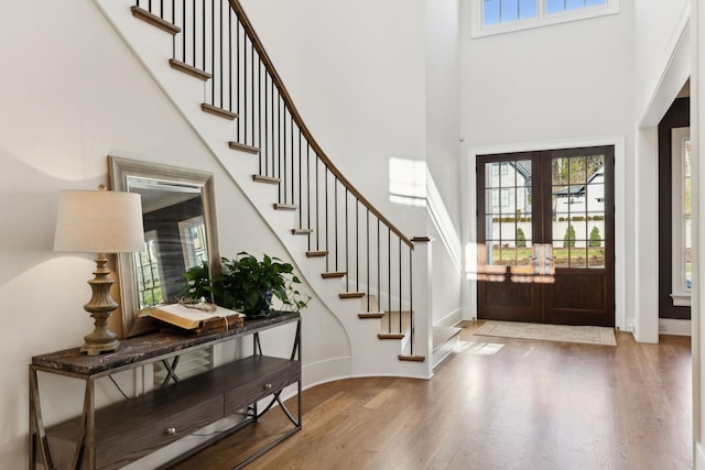 entrance foyer featuring hardwood / wood-style flooring, french doors, and a towering ceiling