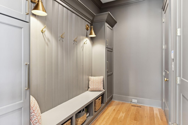 mudroom featuring ornamental molding and light wood-type flooring