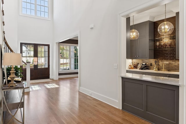 foyer with a high ceiling, sink, hardwood / wood-style floors, and french doors