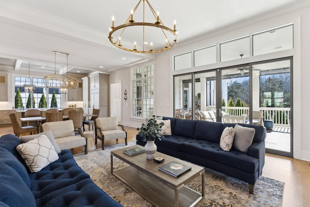 living room with beamed ceiling, a notable chandelier, light hardwood / wood-style floors, crown molding, and french doors