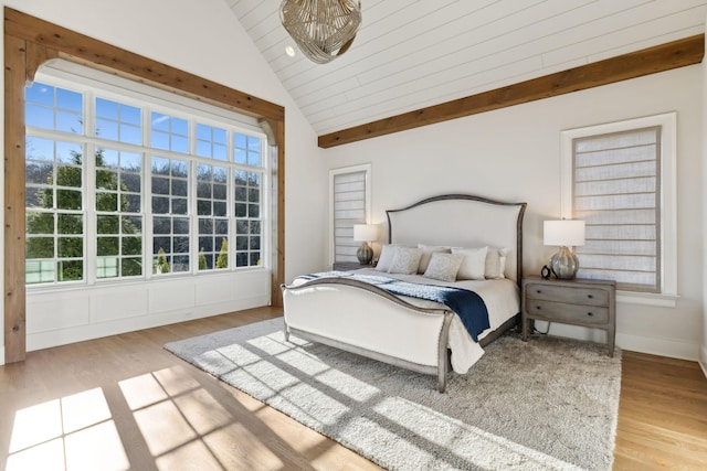 bedroom with lofted ceiling, multiple windows, and light hardwood / wood-style flooring