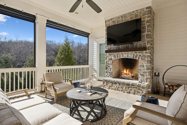 sunroom featuring ceiling fan and an outdoor stone fireplace