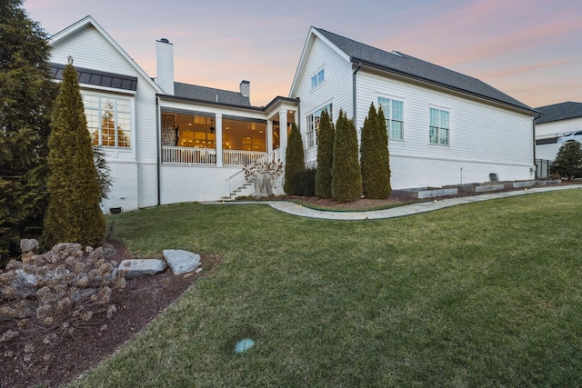 property exterior at dusk with a yard