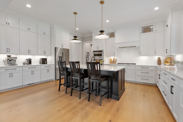 kitchen with tasteful backsplash, white cabinetry, appliances with stainless steel finishes, and hanging light fixtures