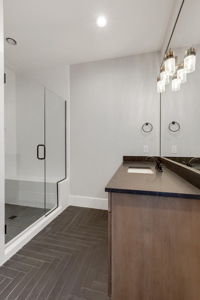 bathroom with a shower with door and vanity