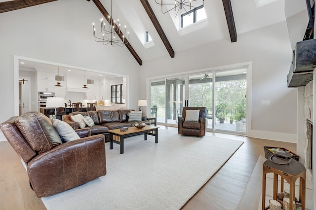 living room featuring light hardwood / wood-style flooring, an inviting chandelier, beam ceiling, high vaulted ceiling, and a fireplace