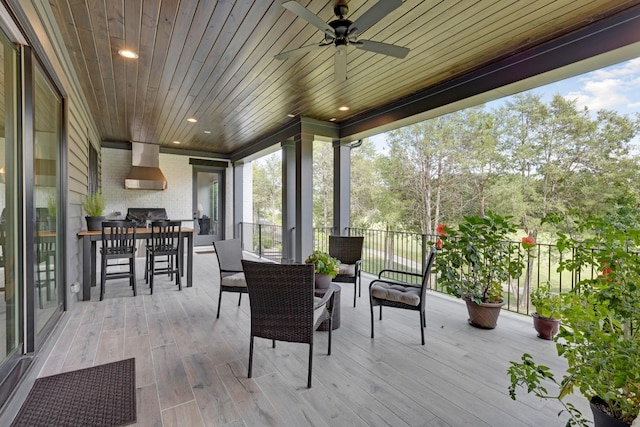 wooden terrace with an outdoor living space, a grill, and ceiling fan