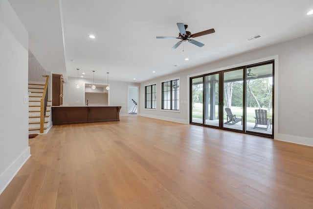 unfurnished living room with ceiling fan, sink, and light wood-type flooring