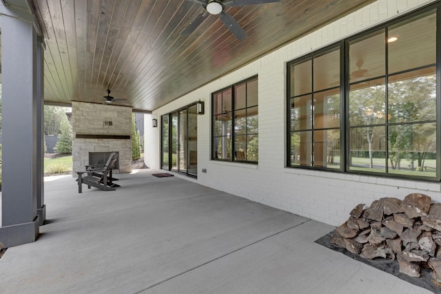 view of patio / terrace with ceiling fan and an outdoor stone fireplace