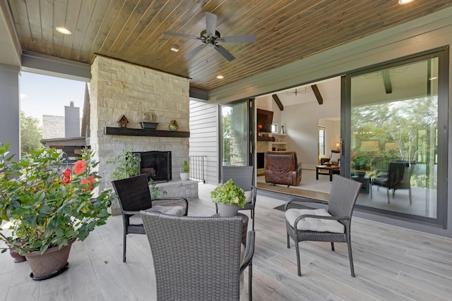 view of patio with an outdoor living space with a fireplace and ceiling fan