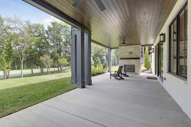 view of patio / terrace featuring ceiling fan and an outdoor stone fireplace