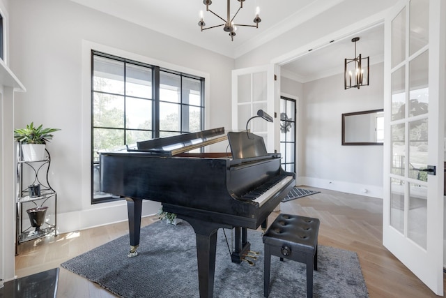 misc room featuring a notable chandelier, crown molding, french doors, and hardwood / wood-style flooring