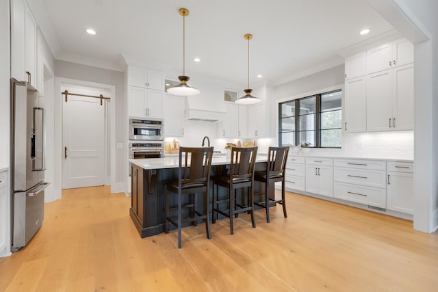 kitchen with decorative light fixtures, stainless steel appliances, decorative backsplash, and white cabinets