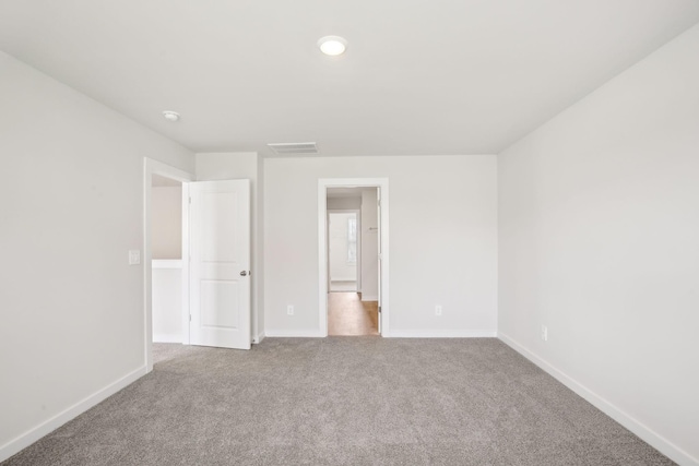 unfurnished bedroom featuring light carpet and baseboards