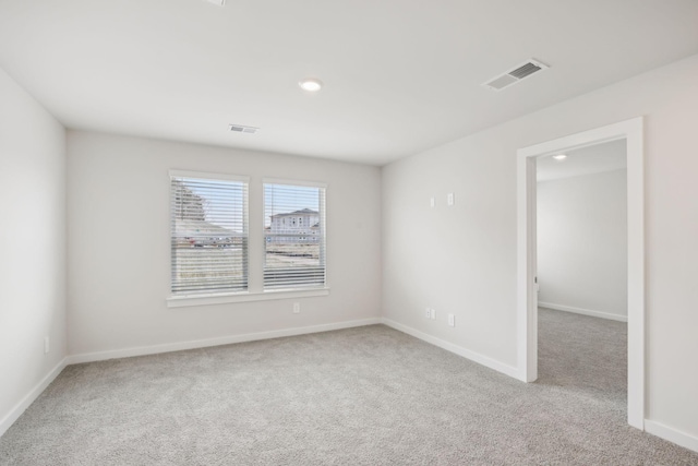 empty room with light carpet, baseboards, and visible vents