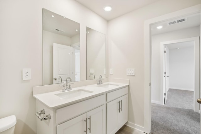 bathroom featuring visible vents, a sink, and double vanity