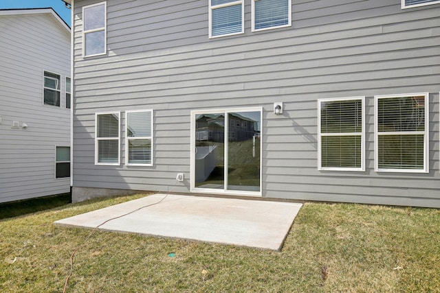 rear view of property with a yard and a patio area