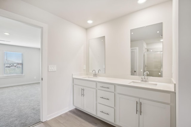 bathroom with double vanity, visible vents, baseboards, and a sink