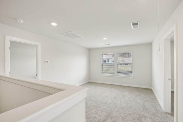 empty room with recessed lighting, visible vents, and light colored carpet