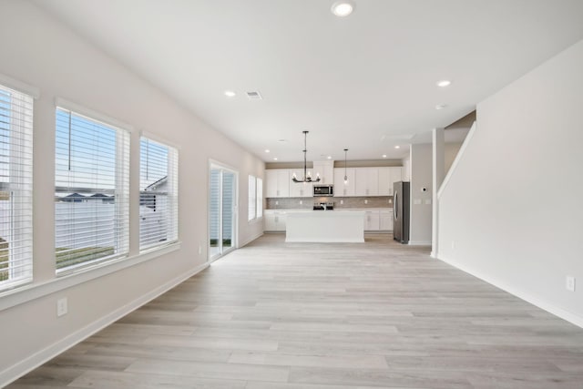 unfurnished living room featuring recessed lighting, baseboards, visible vents, and light wood finished floors