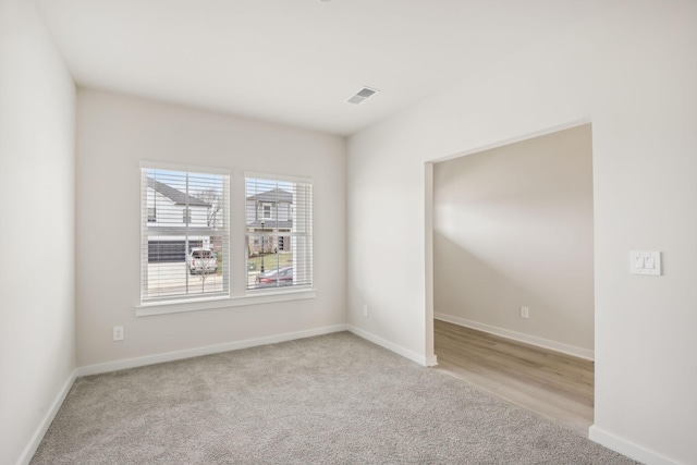 empty room with light carpet, baseboards, and visible vents