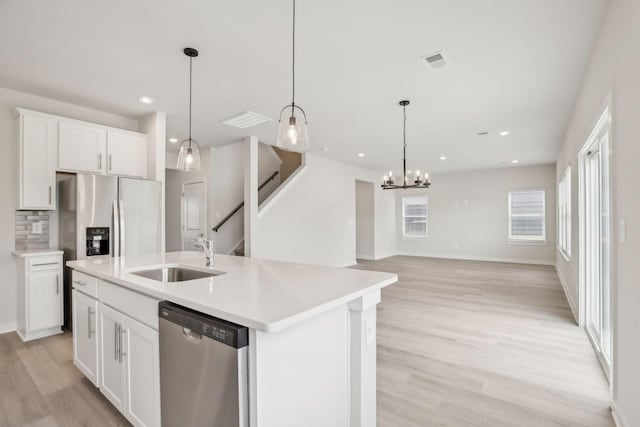 kitchen featuring light countertops, appliances with stainless steel finishes, a sink, and white cabinets