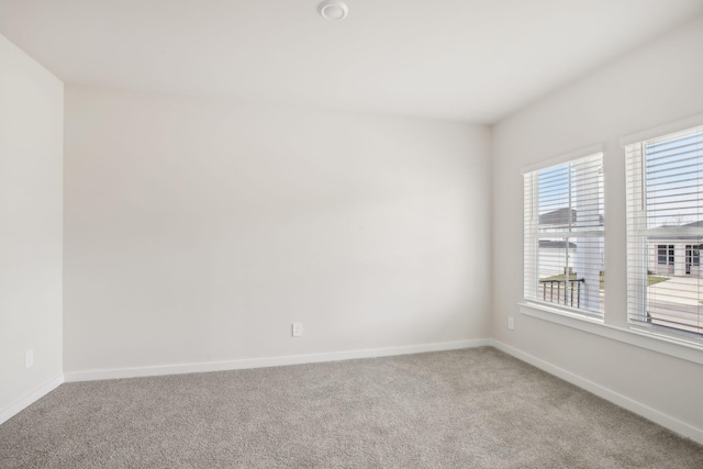 unfurnished room with carpet flooring and baseboards