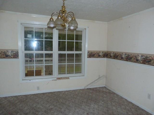 unfurnished dining area featuring a notable chandelier, crown molding, and carpet floors