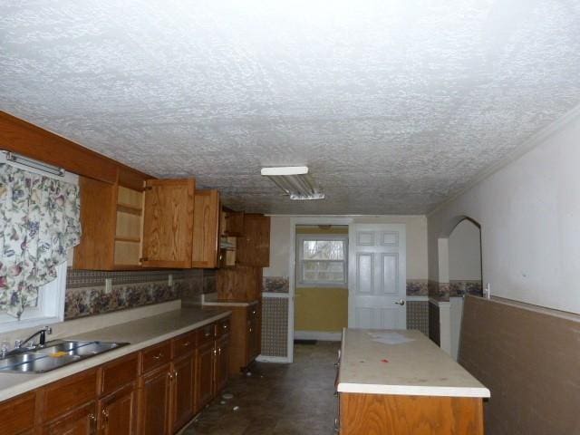 kitchen with sink, a kitchen island, and a textured ceiling