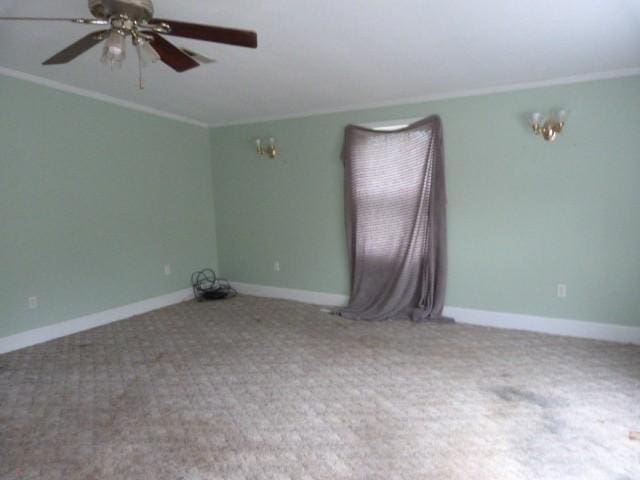 spare room featuring crown molding, ceiling fan, and carpet floors