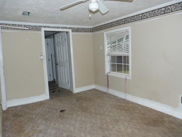 carpeted spare room featuring ceiling fan and a textured ceiling