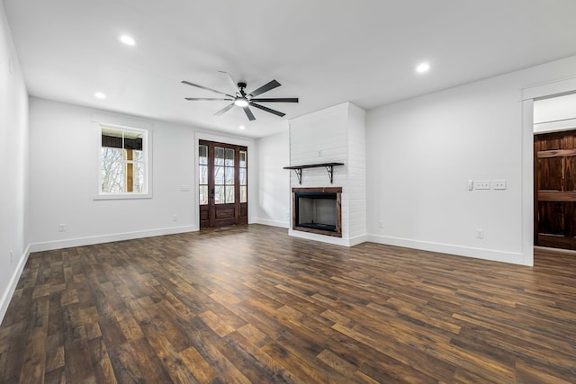 unfurnished living room featuring dark hardwood / wood-style flooring, ceiling fan, a fireplace, and french doors