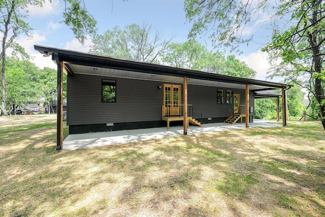 rear view of property featuring a yard, crawl space, and entry steps