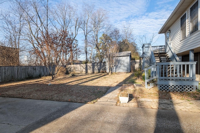 view of yard featuring a shed and a wooden deck