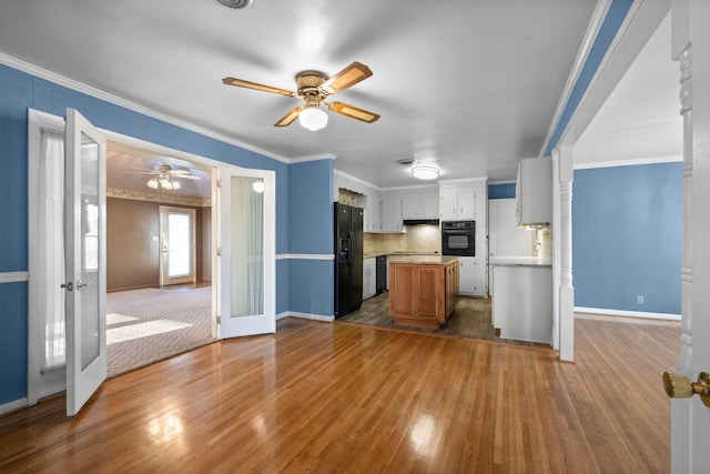 kitchen with white cabinets, decorative backsplash, black appliances, crown molding, and french doors