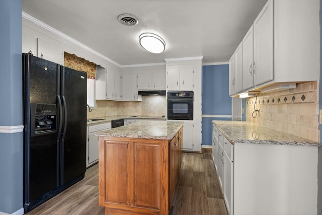 kitchen featuring backsplash, hardwood / wood-style floors, a center island, black appliances, and white cabinets