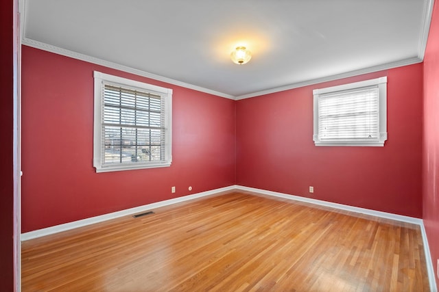 spare room featuring wood-type flooring and ornamental molding