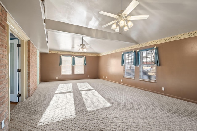 carpeted spare room with brick wall, plenty of natural light, lofted ceiling, and ceiling fan