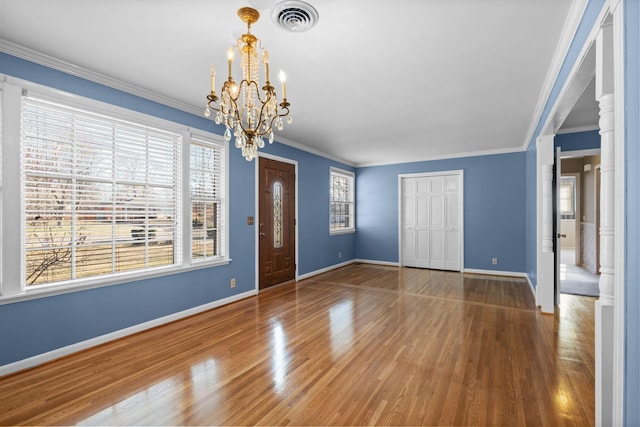 interior space featuring an inviting chandelier, hardwood / wood-style floors, and crown molding