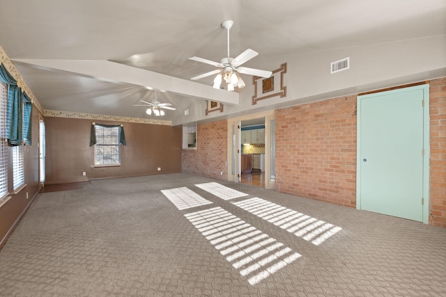 interior space with ceiling fan, brick wall, and vaulted ceiling with beams