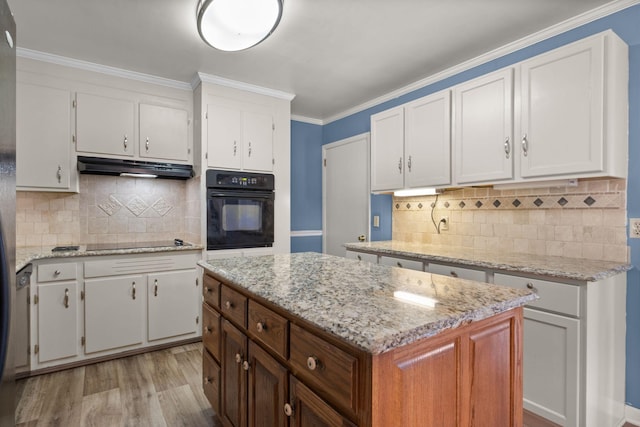 kitchen featuring decorative backsplash, a kitchen island, white cabinets, and black appliances