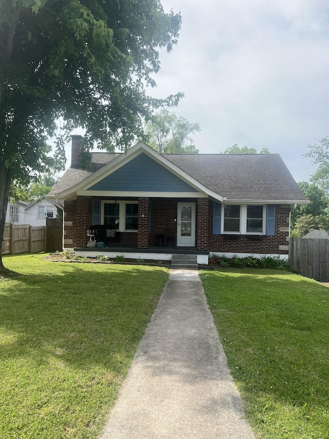 single story home with covered porch and a front yard