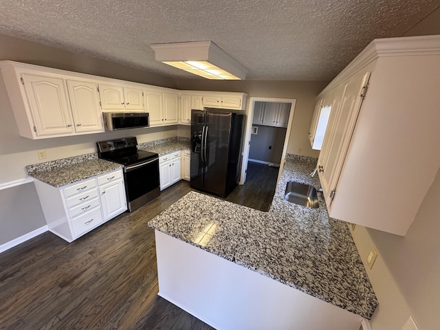 kitchen with appliances with stainless steel finishes, stone countertops, sink, and white cabinets