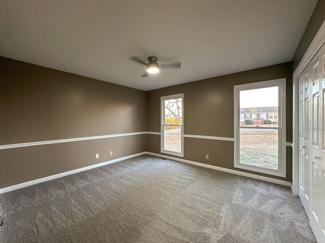 carpeted spare room with plenty of natural light and ceiling fan