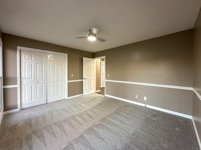 unfurnished bedroom featuring a textured ceiling, a closet, ceiling fan, and carpet flooring