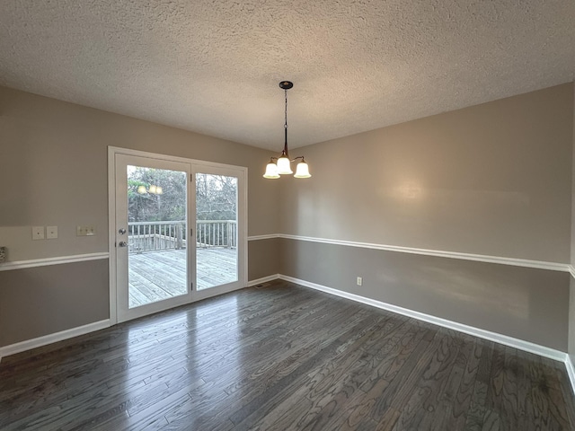 unfurnished dining area featuring dark hardwood / wood-style flooring, a notable chandelier, and a textured ceiling