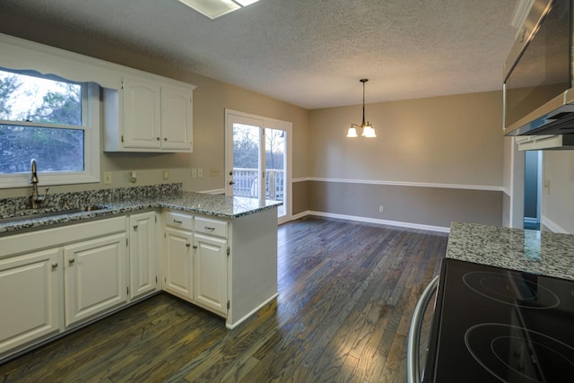 kitchen featuring decorative light fixtures, sink, white cabinets, light stone counters, and electric stove