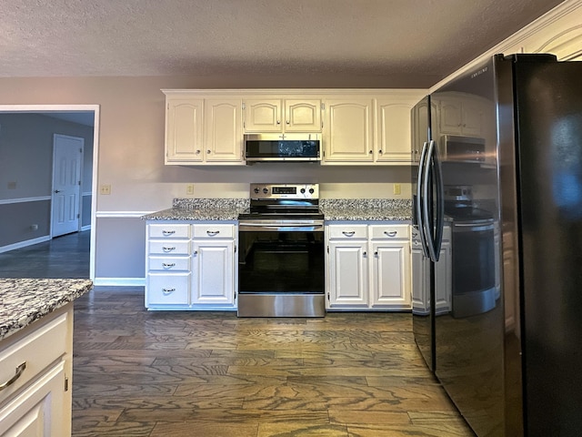 kitchen featuring appliances with stainless steel finishes, white cabinetry, light stone counters, a textured ceiling, and dark hardwood / wood-style flooring