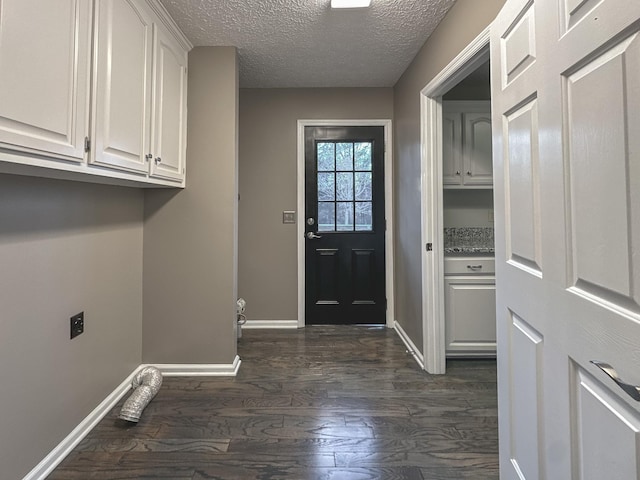 laundry room featuring dark hardwood / wood-style floors, cabinets, a textured ceiling, and hookup for an electric dryer