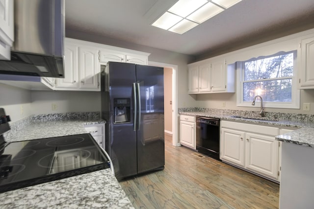 kitchen with electric range oven, black dishwasher, sink, white cabinets, and stainless steel refrigerator with ice dispenser